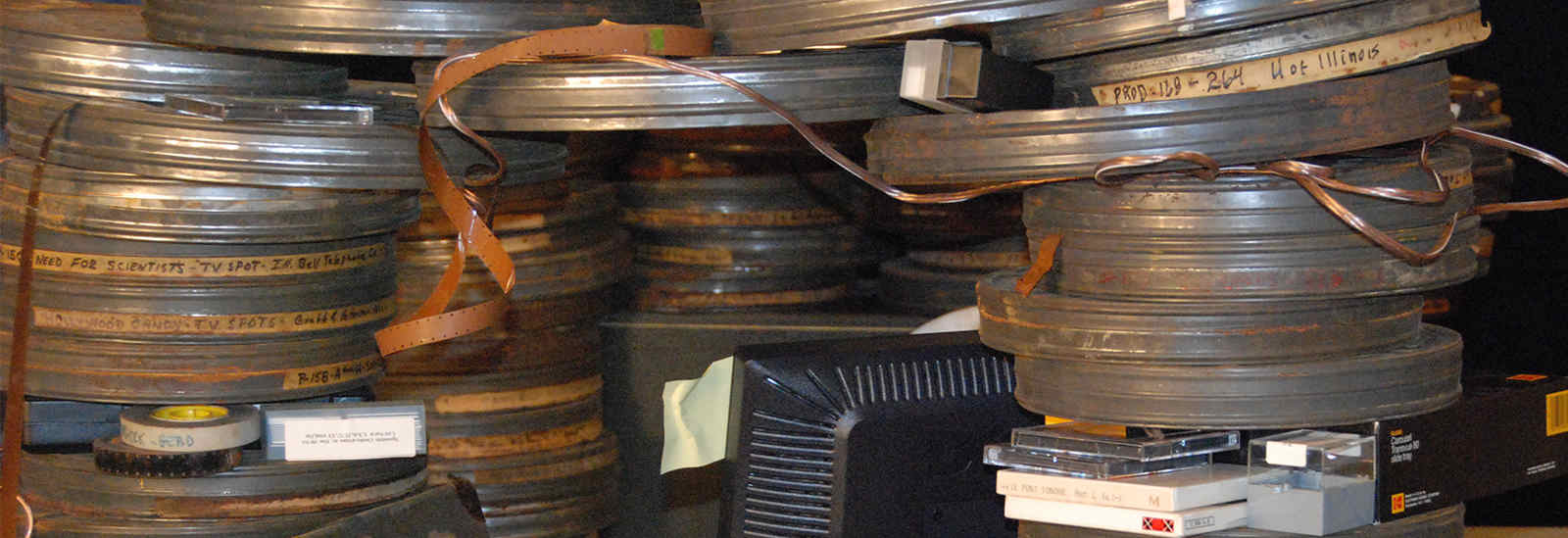Photograph of old film canisters stacked on desk