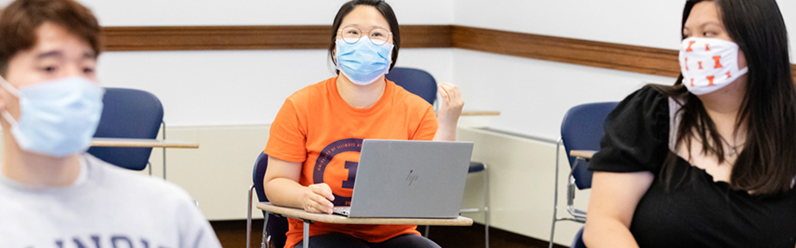 students with laptops wearing masks