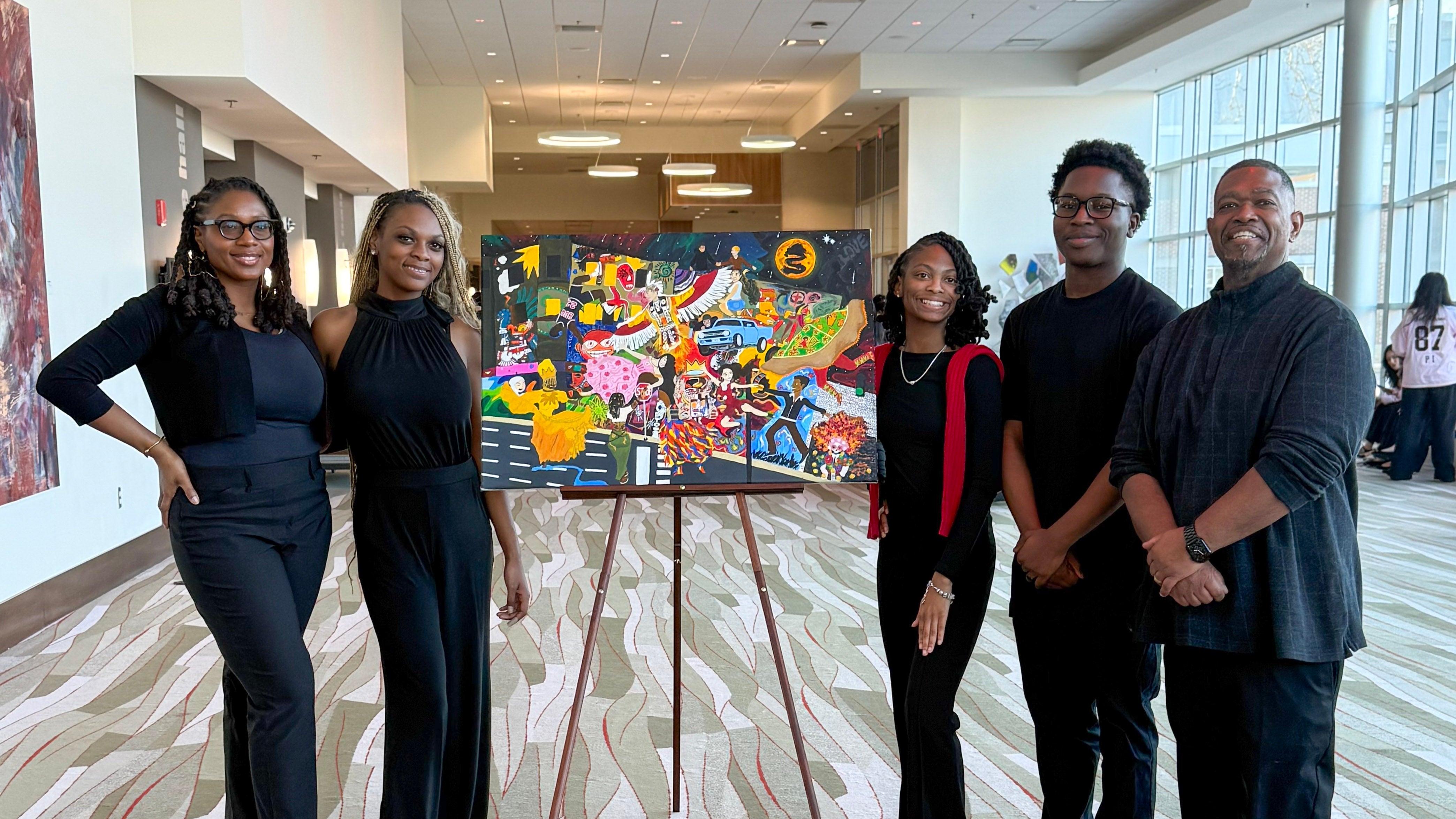 Presenters stand with artwork at the Annual Black & Latinx Summit 2026