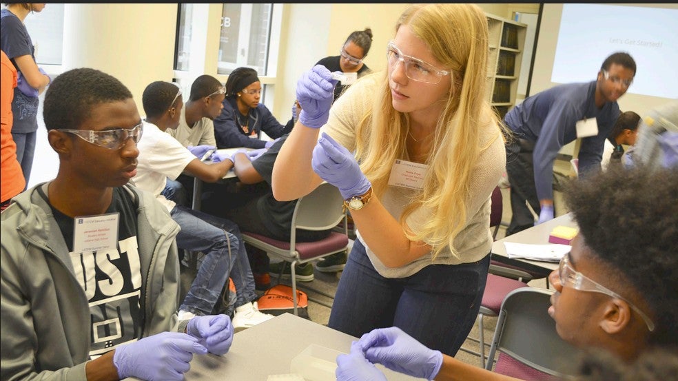 MCB PhD student Katie Frye words with a group of UHS students during a hands-on activity during the I-STEM Camp's MCB Day.