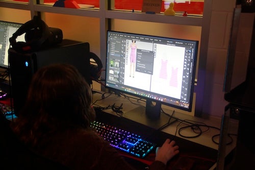 student working on computer designing clothes