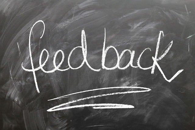 handwritten word 'Feedback' in white chalk on a black chalkboard