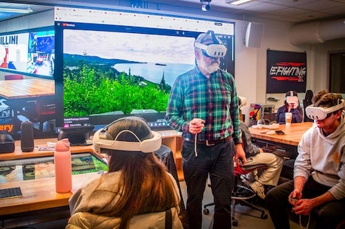 man wearing vr headset doing a demo to a class