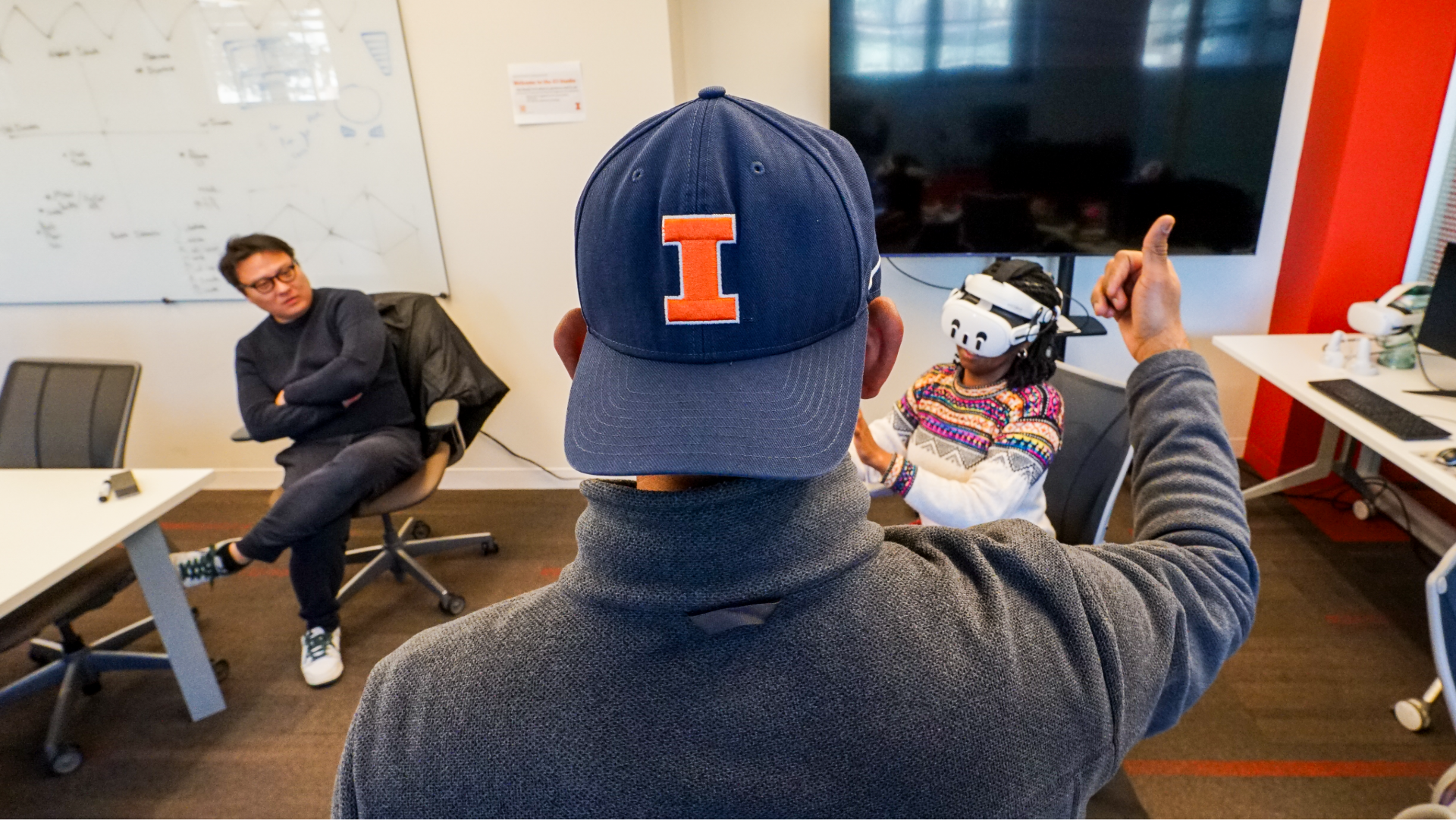 Photo of user testing the VR application with Dr. Fumihiro looking on.