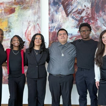 A Group of Attendees at the Annual Black & Latinx 2026 Summit posed in front of large abstract paintings