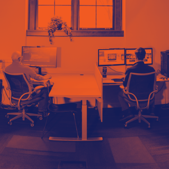 Photo inside X3 Studio of staff in the middle of a collaborative discussion