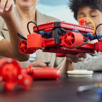 3 kids learning robotics with instructor