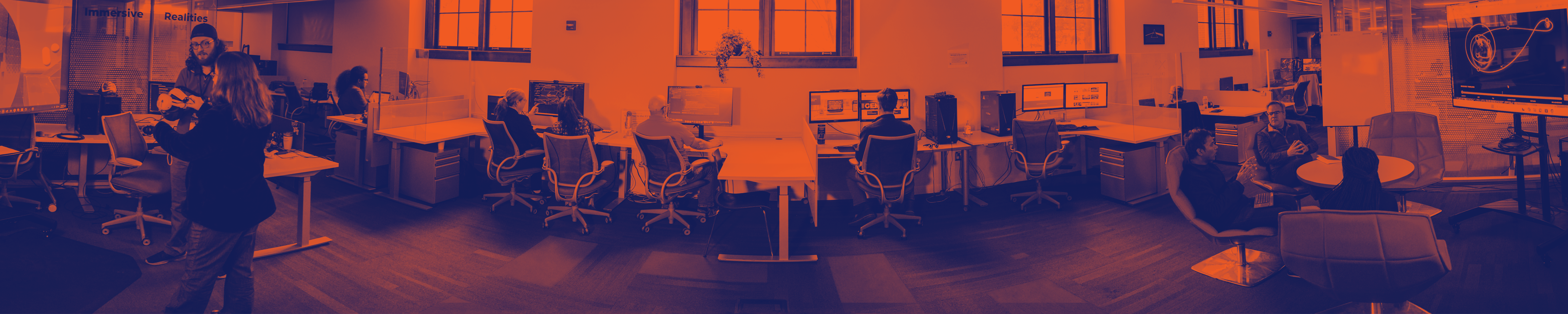 Photo inside X3 Studio of staff in the middle of a collaborative discussion